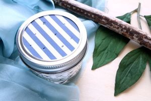 A DIY air freshener made with blue and white striped paper and a canning jar.