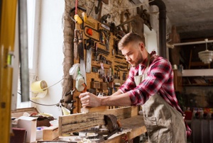 A man uses a jointer planer.
