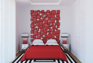 Bedroom with red bedspread and red wall art as a headboard