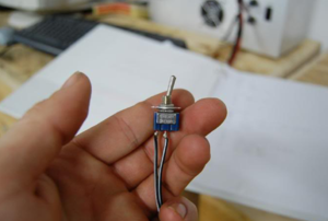 person holding a battery kill switch
