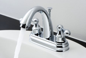 A bathroom faucet with the taps on and the water running.