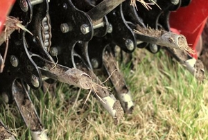 A mechanical aerator pokes holes in a lawn.