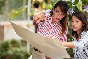 two women in a garden designing from a plan