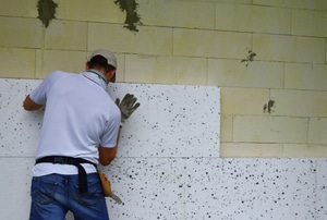 Person installing foam insulation sheets