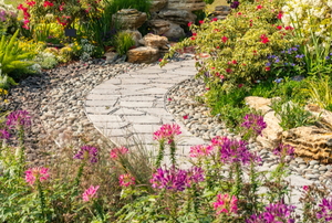 flagstone pathway in flower garden with river rocks