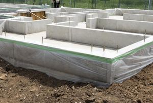 A concrete slab foundation with houses in the background.