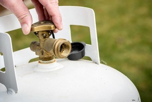 A man adjusts a propane tank.