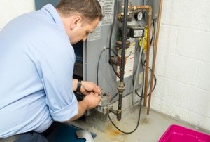 a man works on the connections of a furnace