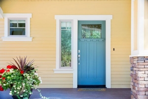 A blue exterior door leading onto a concrete patio.