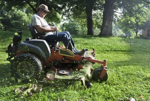 A man on a riding lawn mower.