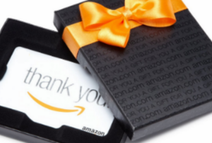An amazon gift card in a black box with an orange bow