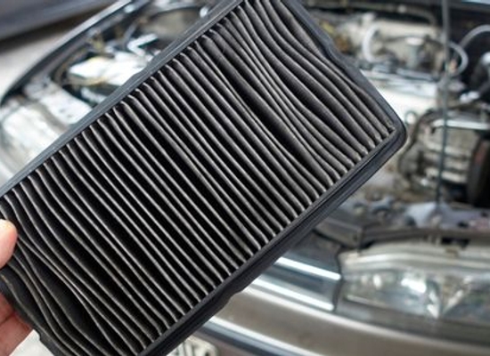 hand holding a dirty car engine AC filter