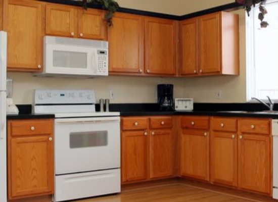 refinished kitchen cabinets with white appliances