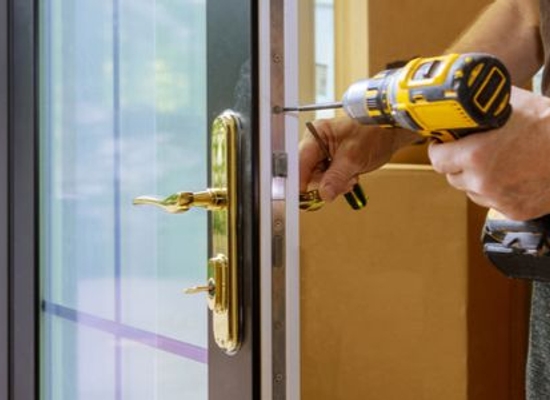 hands using drill to replace hardware in front door