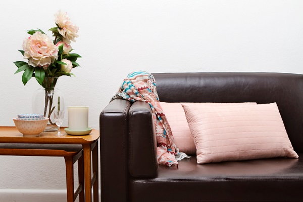couch with pink accent pillow and flowers