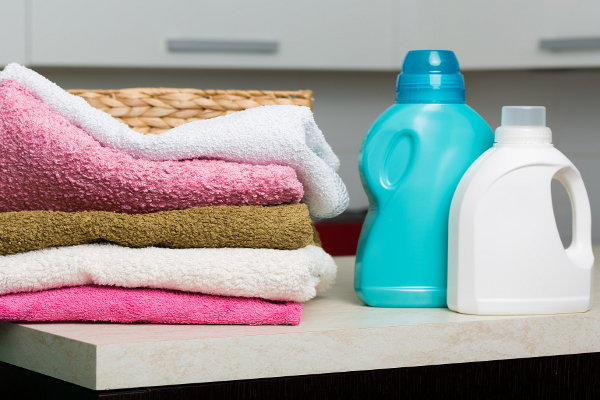 A stack of towels and a couple bottles of laundry detergent. 