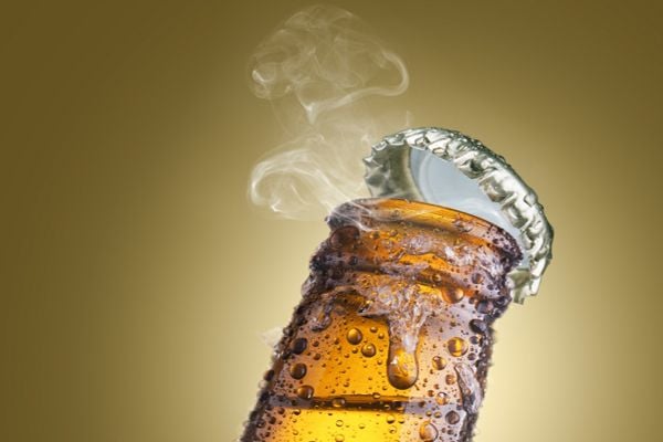 bottle cap coming off a cold beer