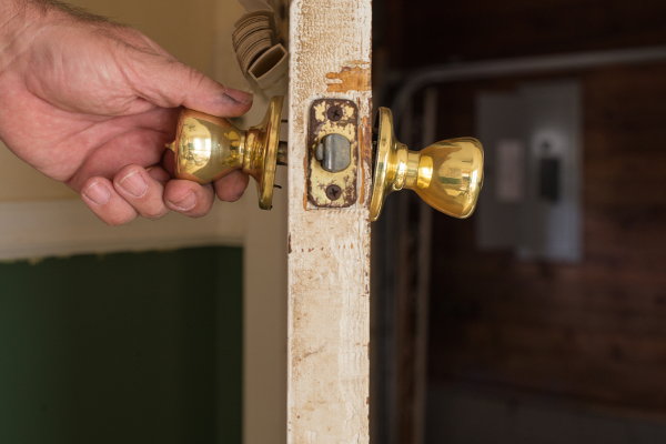 holding a partially removed doorknob from a door
