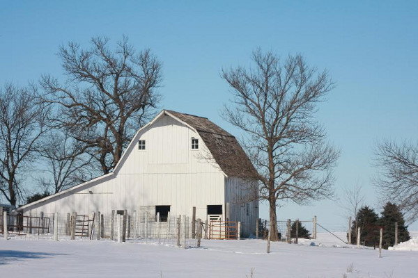 A saltbox roofline on a farmhouse surrounded by snow. 
