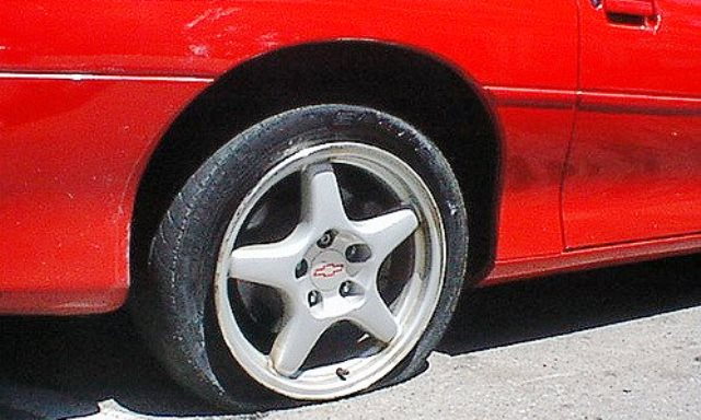 red car with a flat tire