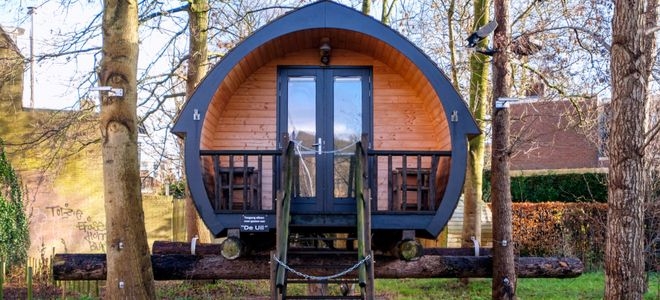 a curved tiny house cabin elevated on logs