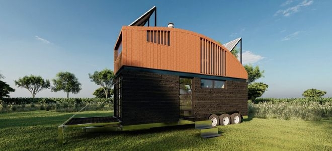 tall mobile home with curved roof and solar panels on a trailer