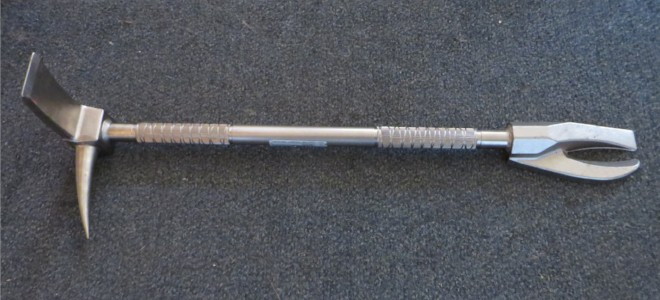 a multi-purpose metal halligan bar tool on carpet