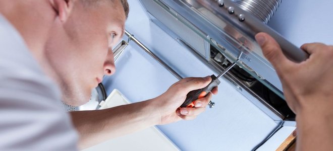 man putting together an exhaust fan