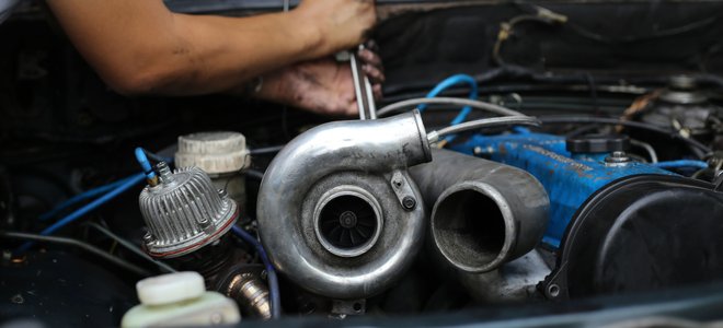 A man works on a turbo diesel engine.