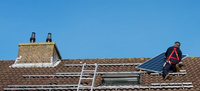 um homem instala painéis solares.