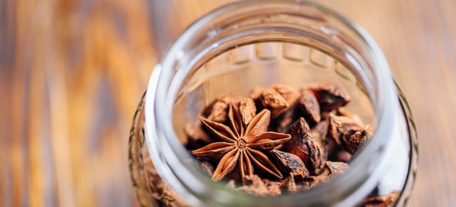 Potpourri in a glass jar on a wood surface. 