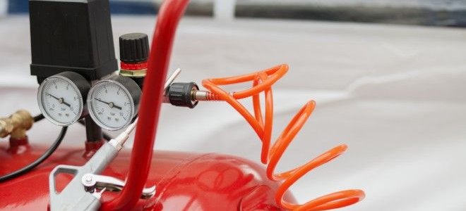 red air compressor with wrench laying on top