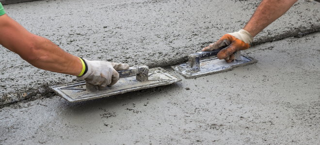 two people using trowels to smooth out concrete