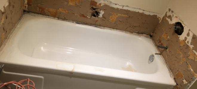 old tub with surrounding wall ripped out