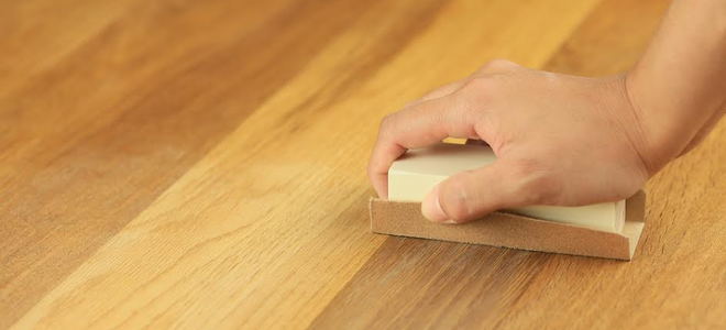 moving a sanding block across wood surface