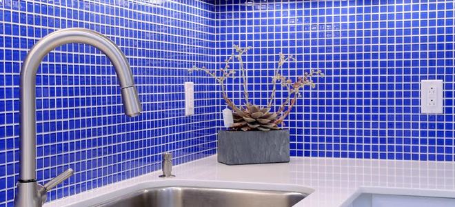 kitchen with blue tile backsplash and large stainless steel sink