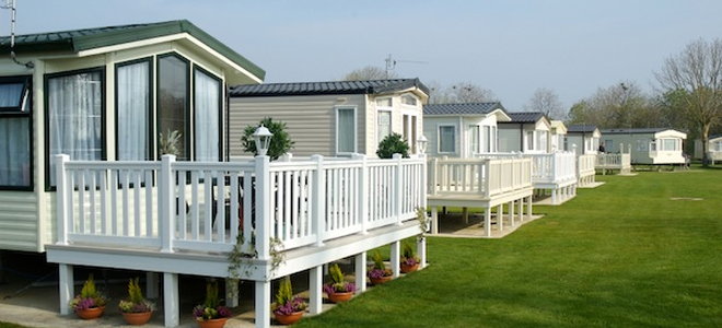 row of mobile homes surrounded by green grass