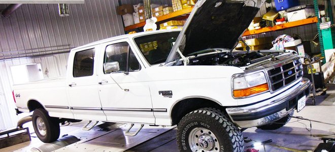 White Ford truck with hood up in a shop