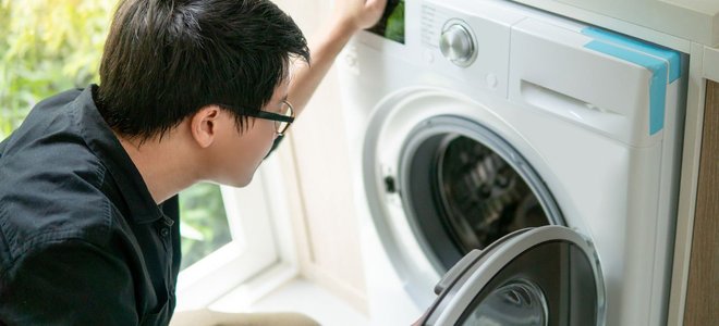 Man looking inside a dryer