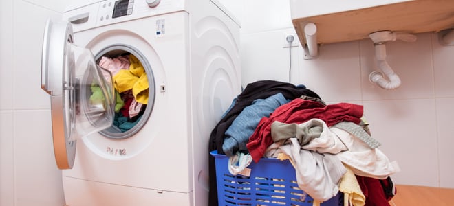 Clothes next to a washing machine.