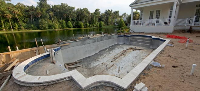 A pool being constructed in a backyard. 
