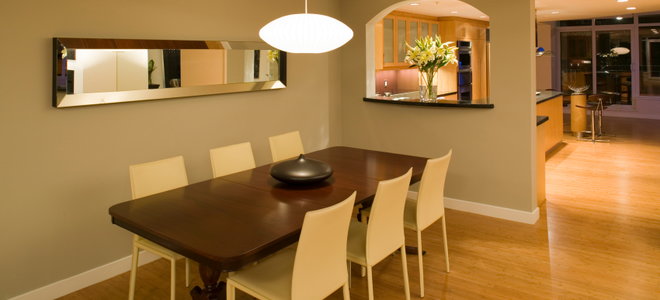 hanging light centered over a dining table and chairs