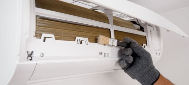 hand in glove brushing air conditioner filter