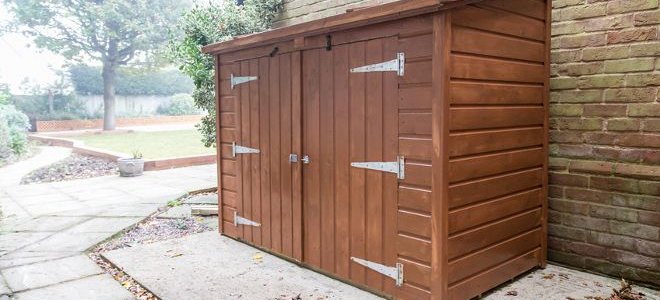 A wooden shed outside a house.