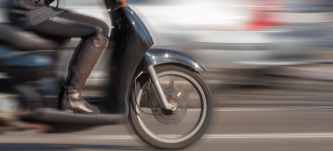 blurring image of rider on a scooter