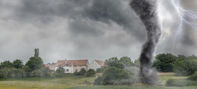 tornado moving across land with house in the background