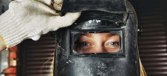 woman wearing a welding mask and gloves