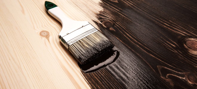brush laying on a partially varnished wood surface