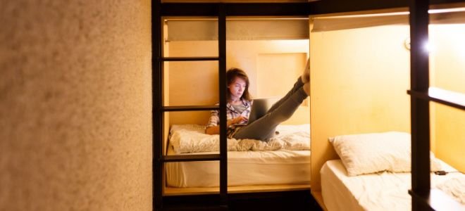 girl with laptop in hostel bed