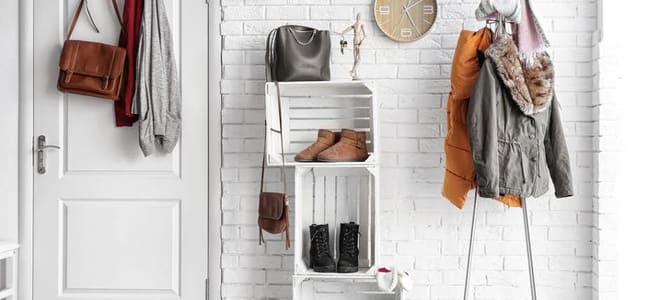 A white minimalist entryway with storage for coats and shoes. 